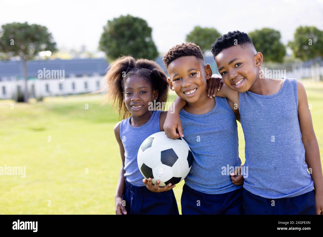Portrait of happy african american schoolchildren playing football on ...