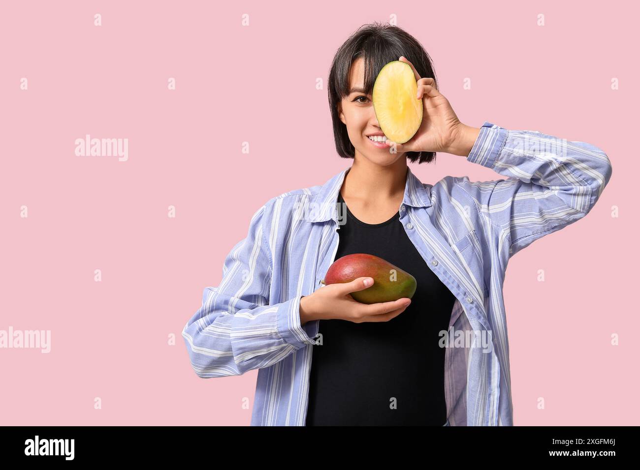 Beautiful young woman with ripe mangoes on pink background Stock Photo ...