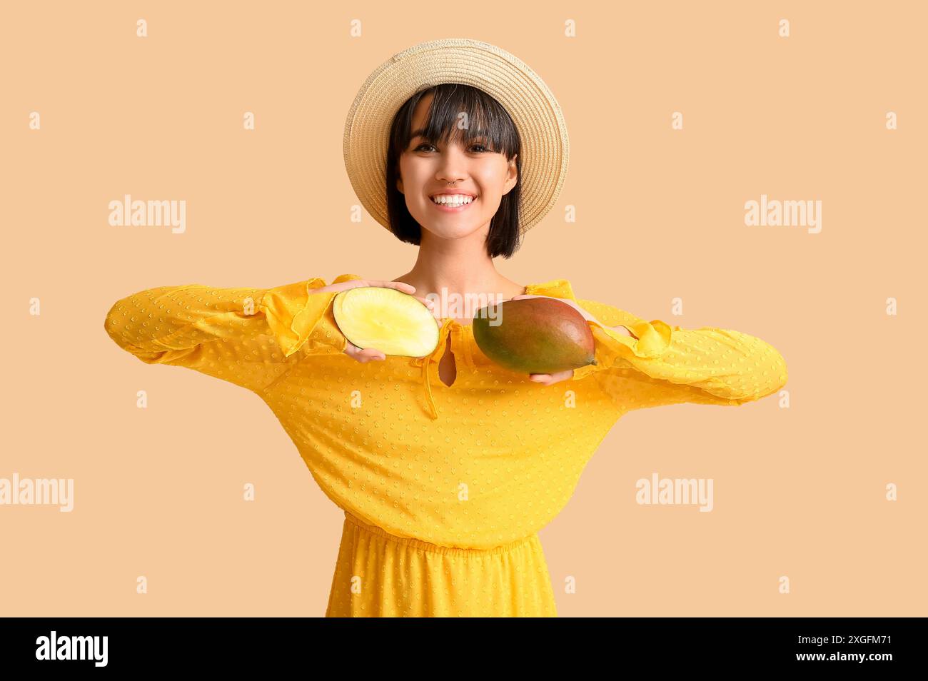 Beautiful young woman with ripe mangoes on beige background Stock Photo ...