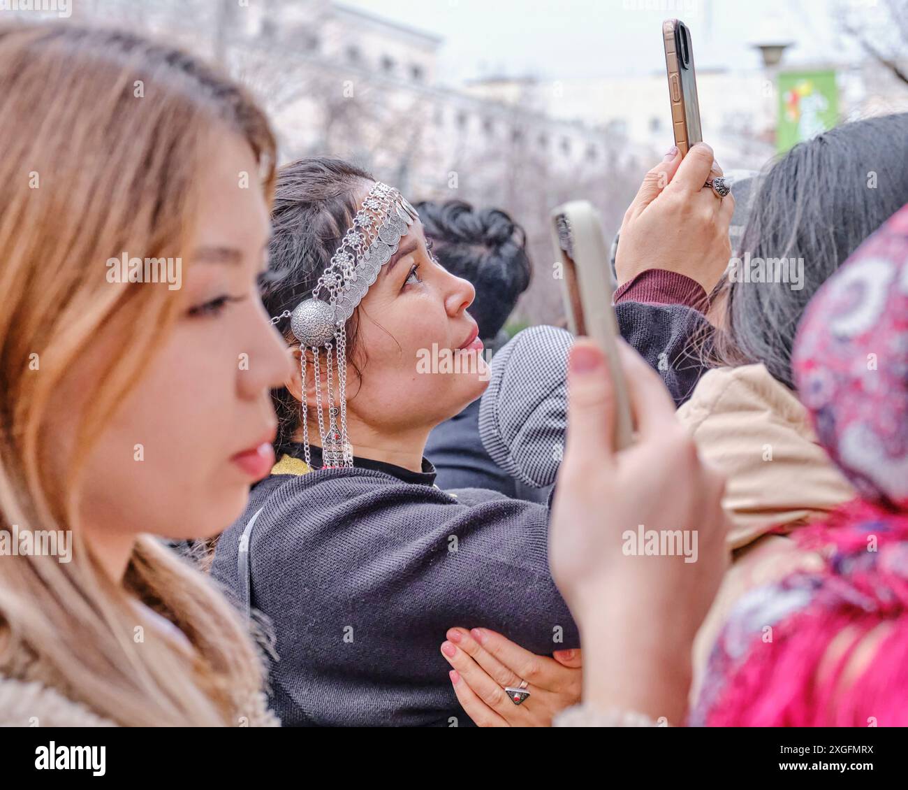 Almaty, Kazakhstan - March 21, 2024: People filming concert on their phones in crowd during celebration of spring holiday of Nowruz. Selective focus Stock Photo