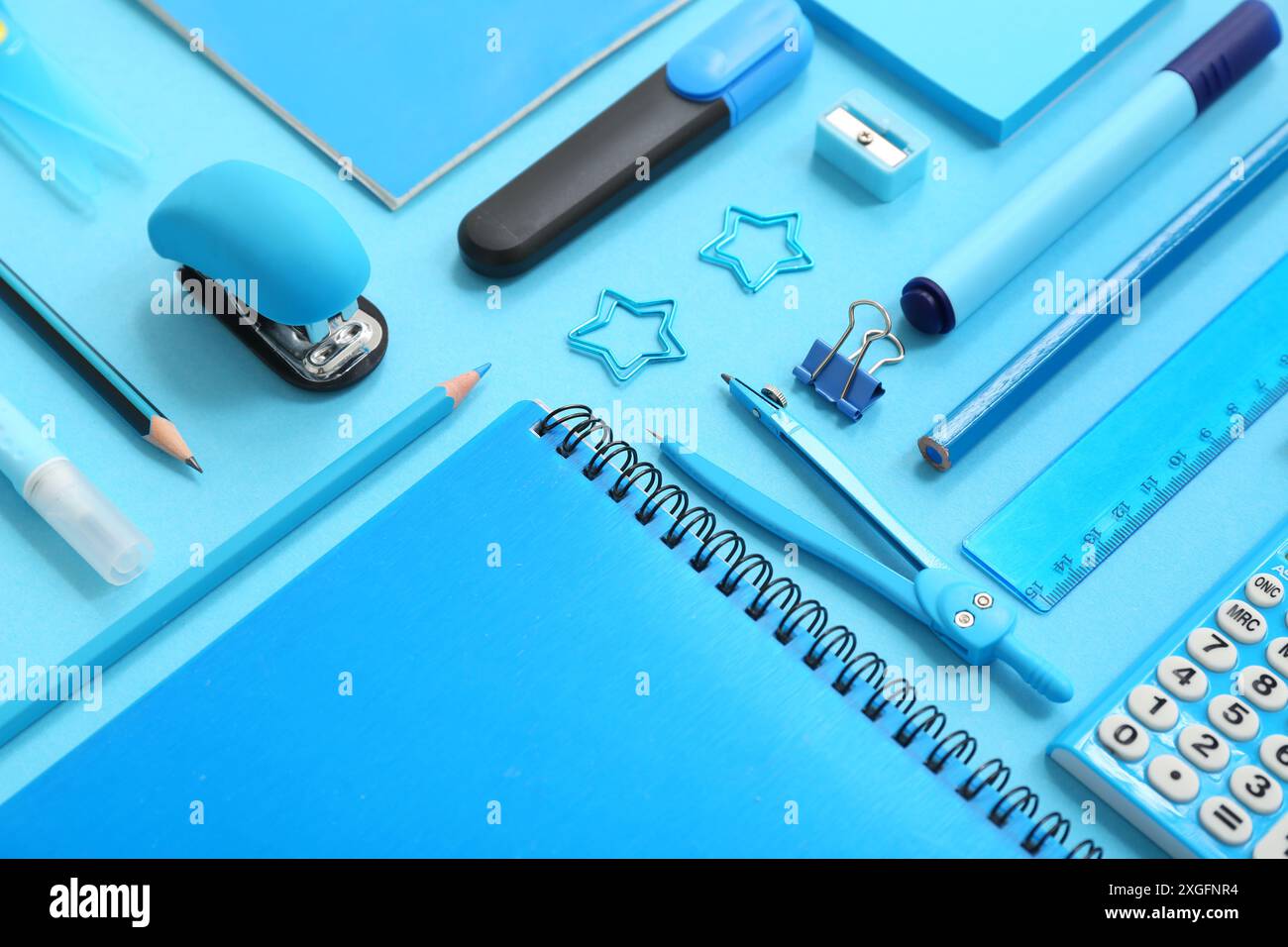 Composition with notebooks and different stationery on blue background, closeup Stock Photo