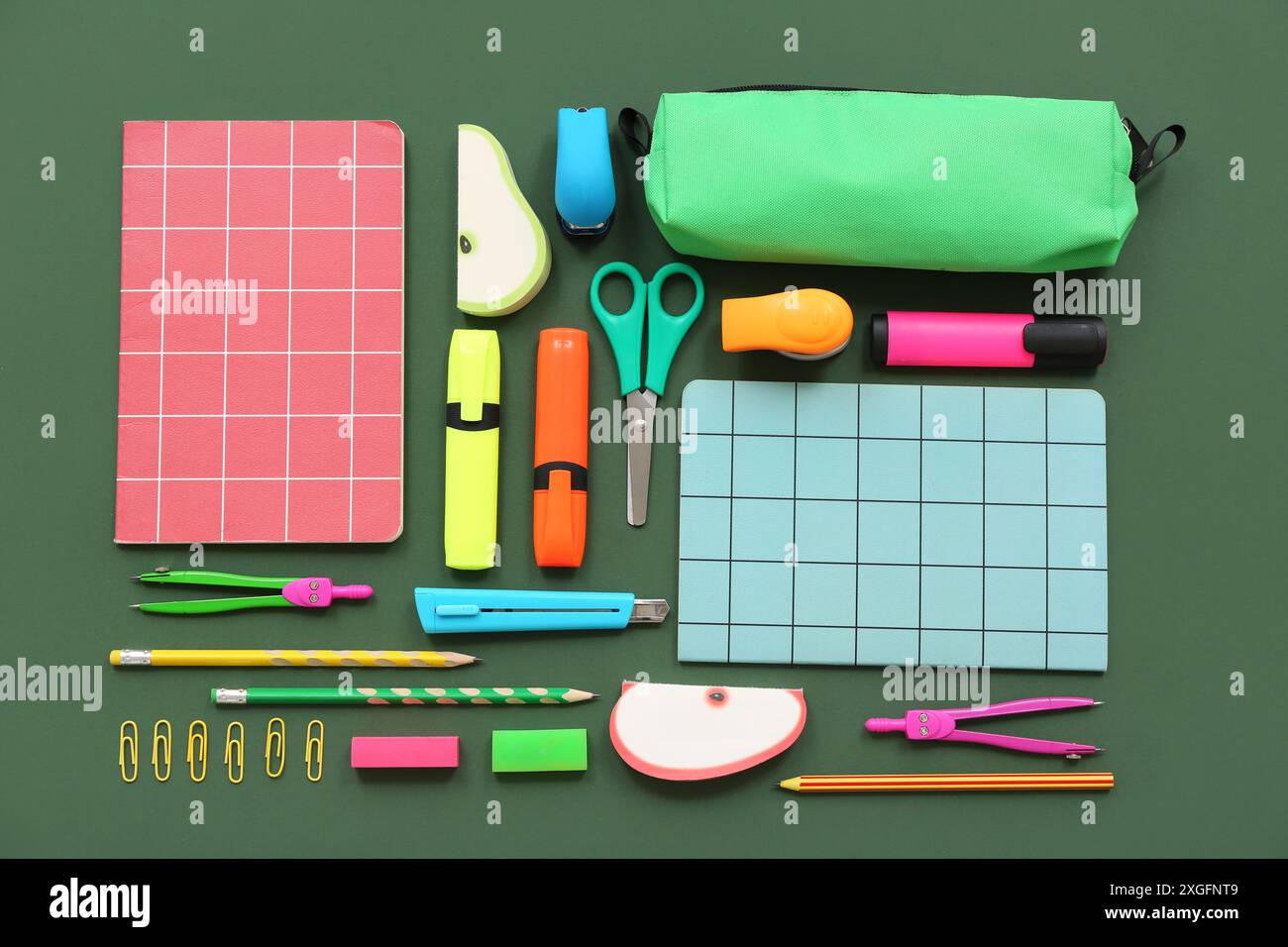 Composition with notebooks and different stationery on green background Stock Photo