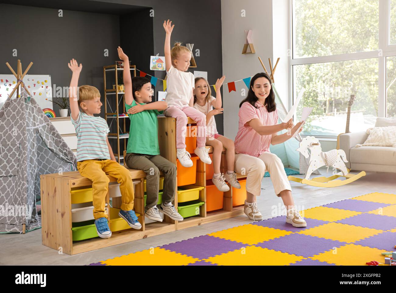 Small Children Learning Little children with nursery teacher learning letters in kindergarten ...