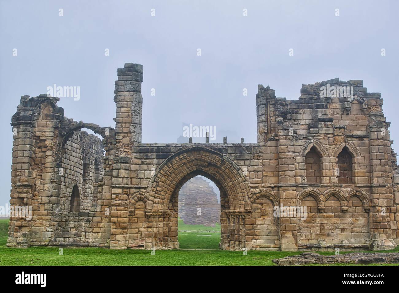 A foggy scene of ancient stone ruins with arched doorways and windows ...