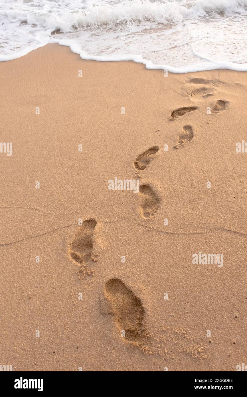 Foot prints on a sandy beach. Texture background Footprints of human feet on the sand near the water on the beach. selective focus, nobody Stock Photo