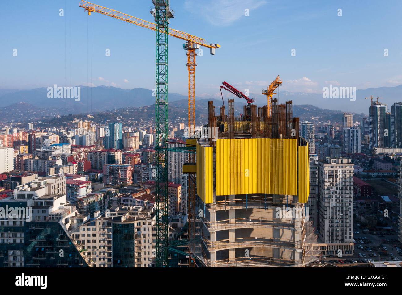High-rise building under construction with cranes, set against backdrop ...