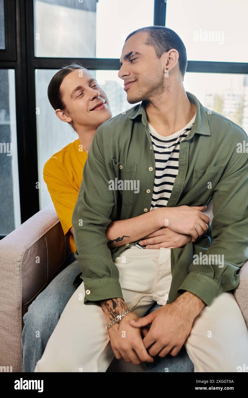 A young gay couple embraces in a modern apartment, showcasing their
