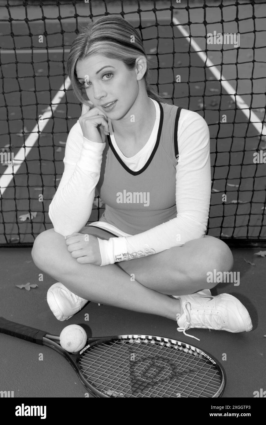 Caucasian Teen Girl in Tennis Outfit Leaning Against Net with Racket and Ball. USA Stock Photo