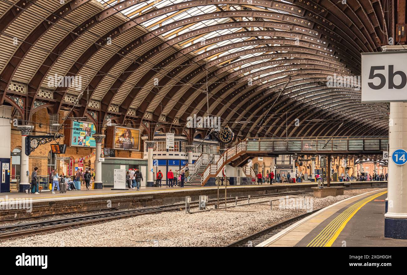 A railway station concourse under a 19th Century iron canopy. A ...