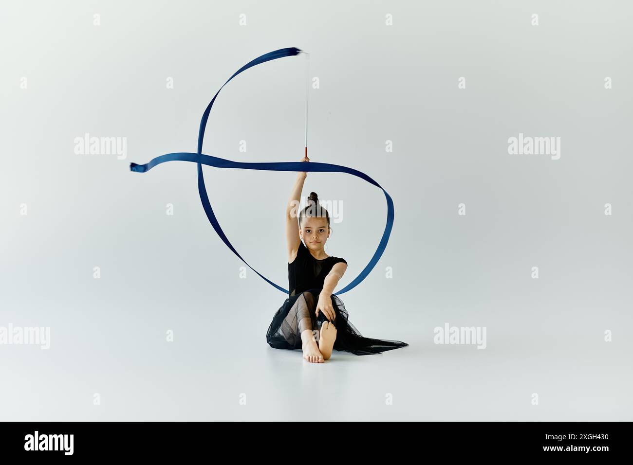 A young girl with a prosthetic leg performs gymnastics with a blue ...