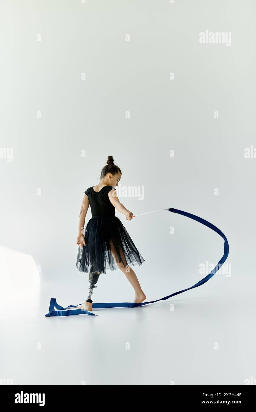A young girl with a prosthetic leg performs a gymnastics routine with a ...