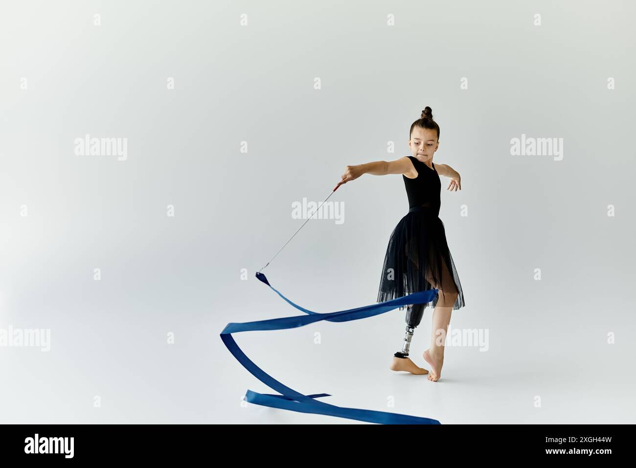 Prosethetic Ribbon A young gymnast with a prosthetic leg performs with a blue ribbon Stock ...