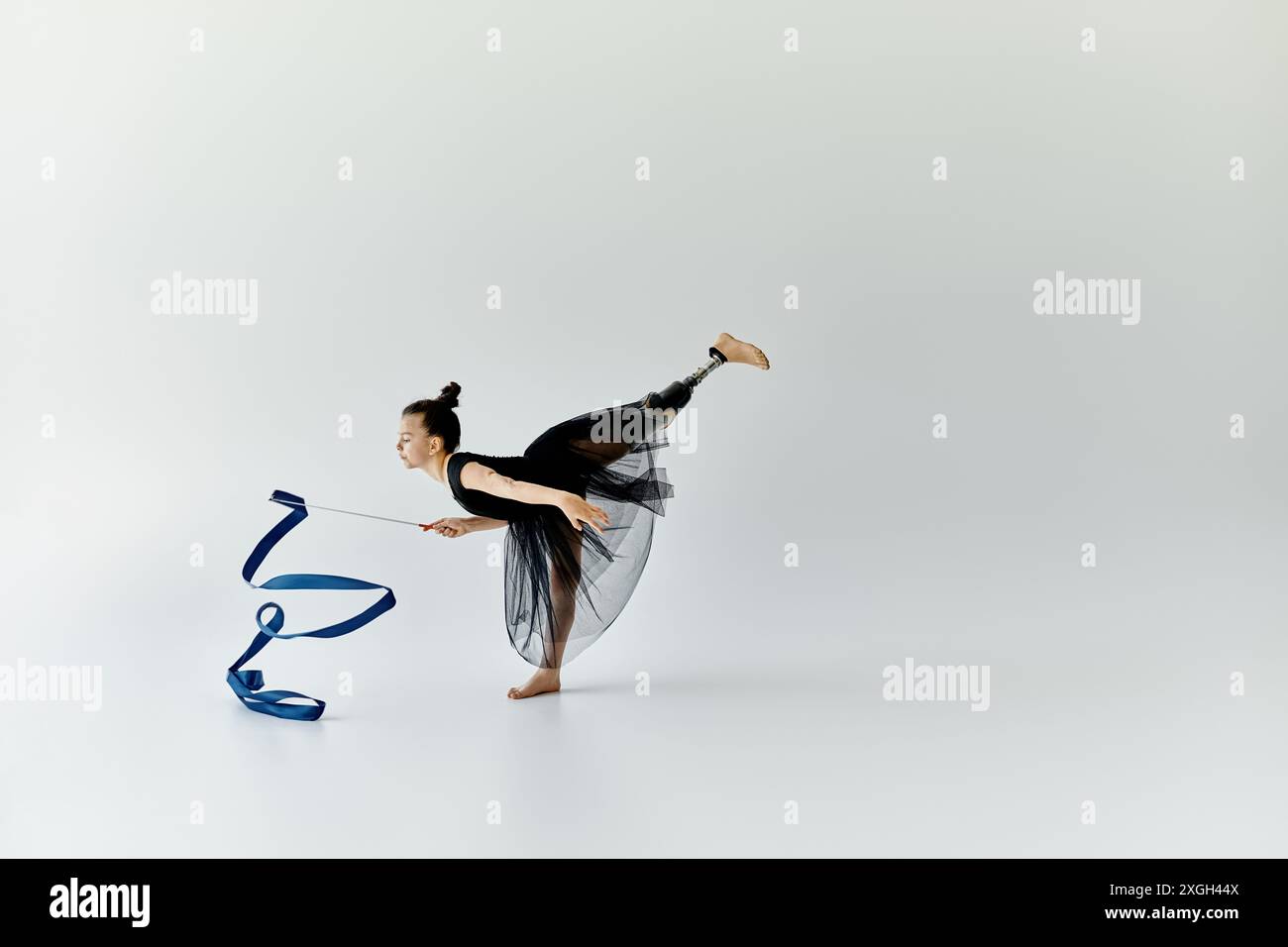 A young gymnast with a prosthetic leg performs a graceful routine with ...
