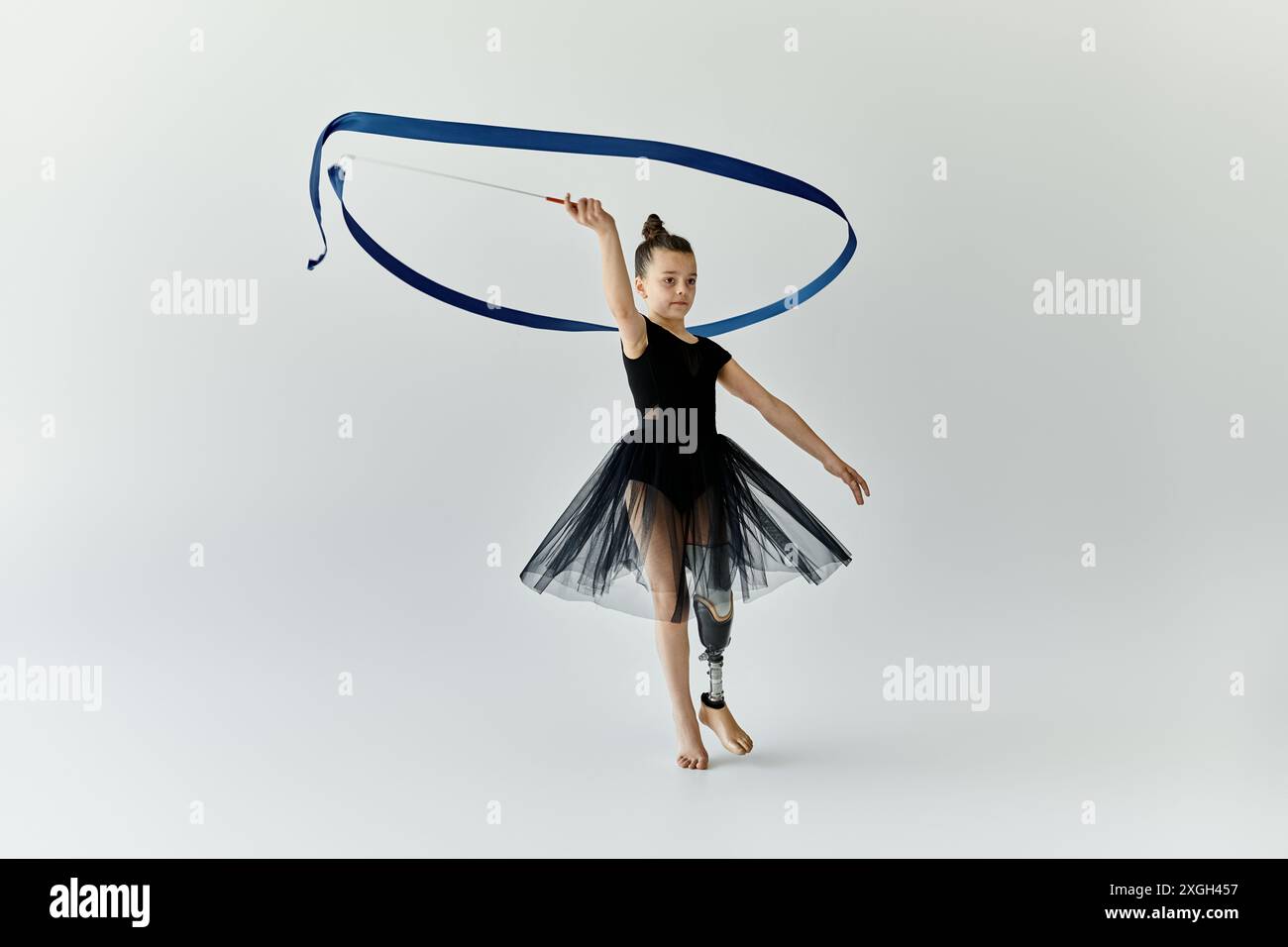 A young girl with a prosthetic leg performs a rhythmic gymnastics ...