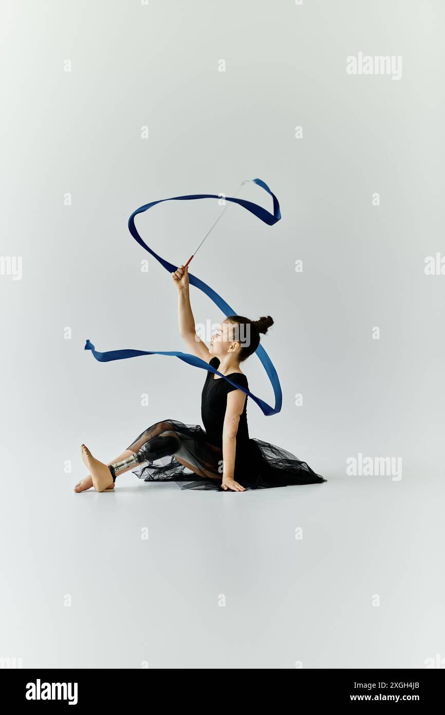 A young girl with a prosthetic leg performs a graceful ribbon routine ...