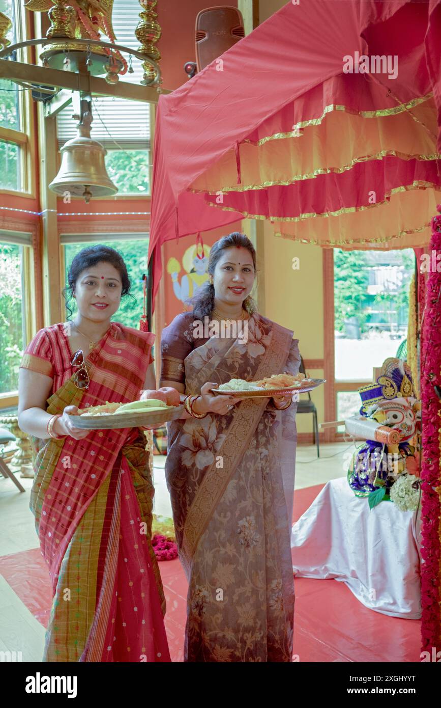Women at the Wilton Hindu Temple prepare food offerings to their deities inside the temple. In summer 2024. Stock Photo