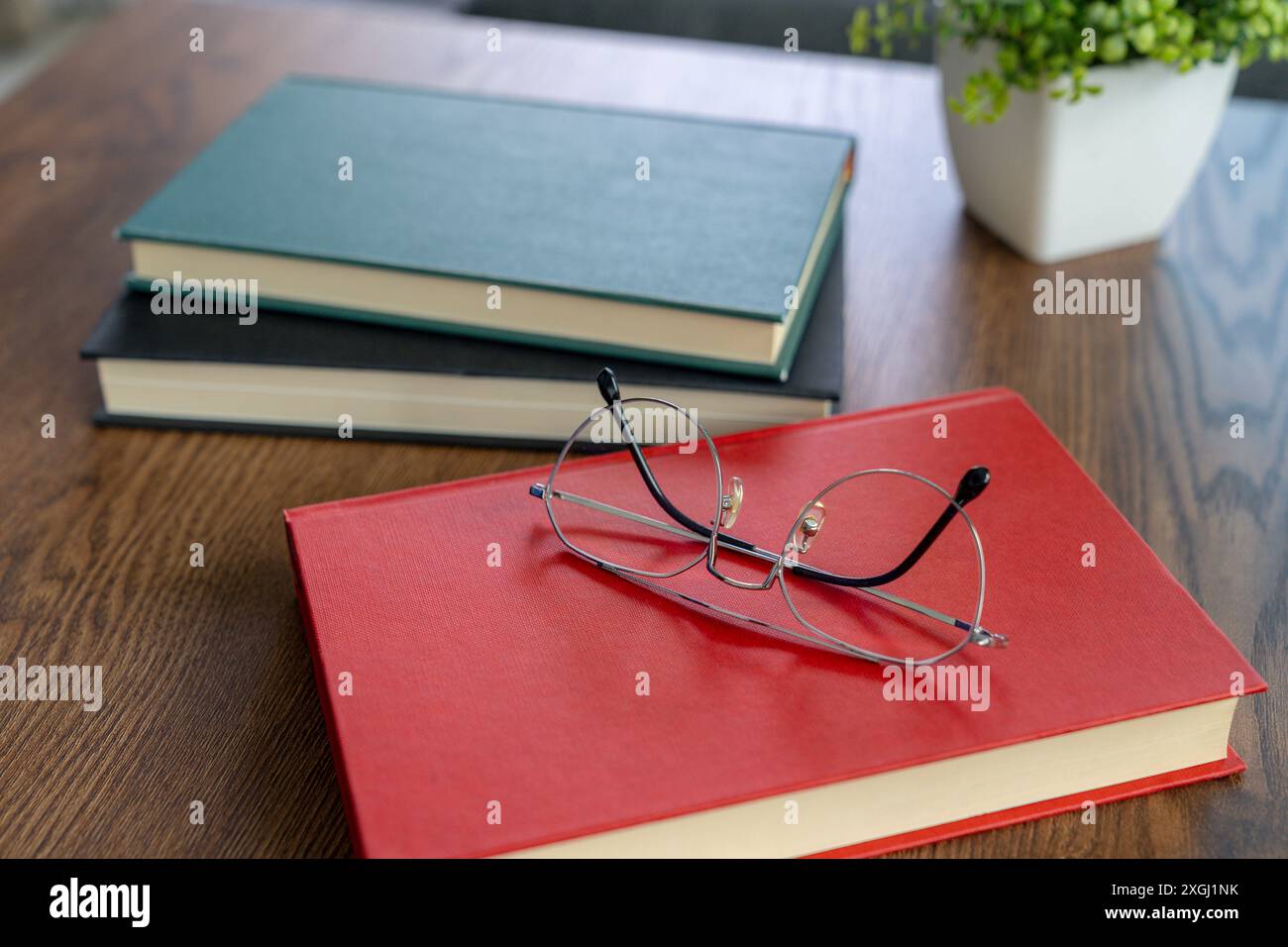 Glasses resting on a book during a break from reading Stock Photo