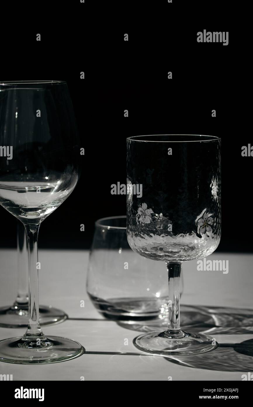 Assorted glassware for various drinks in sunlight. Stock Photo