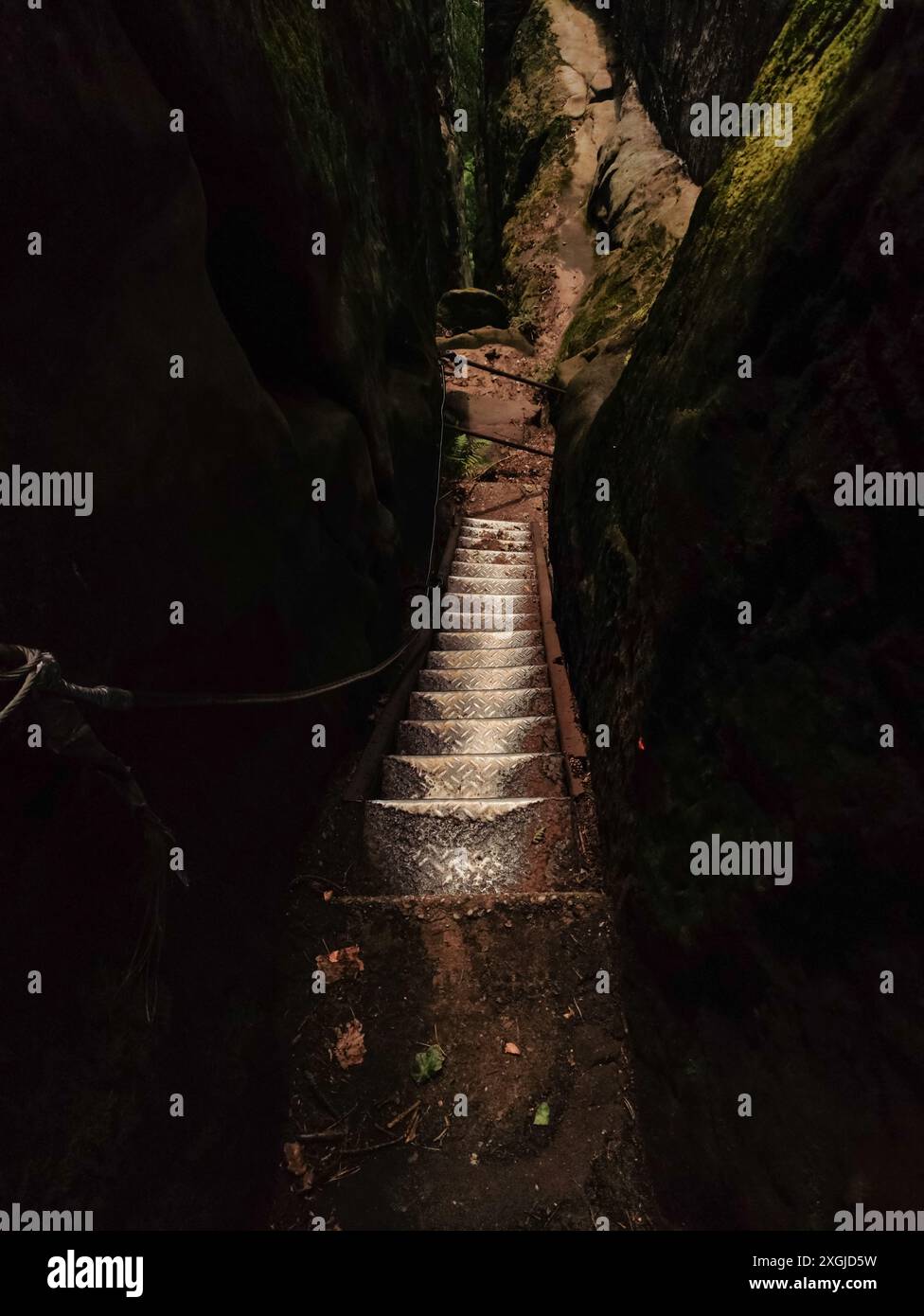 Stone steps wind down a narrow canyon, shaded by tall rock walls ...