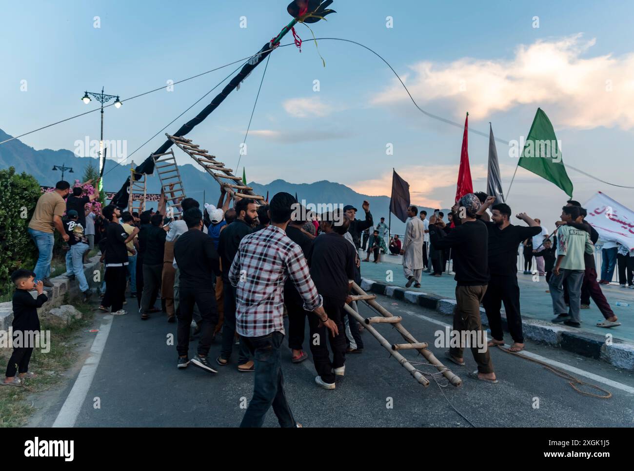 Kashmiri Shia Muslims erect a tall religious flag on a road during ...