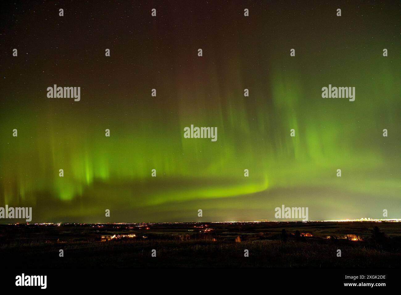 Green northern lights illuminating night sky over a cityscape Stock ...