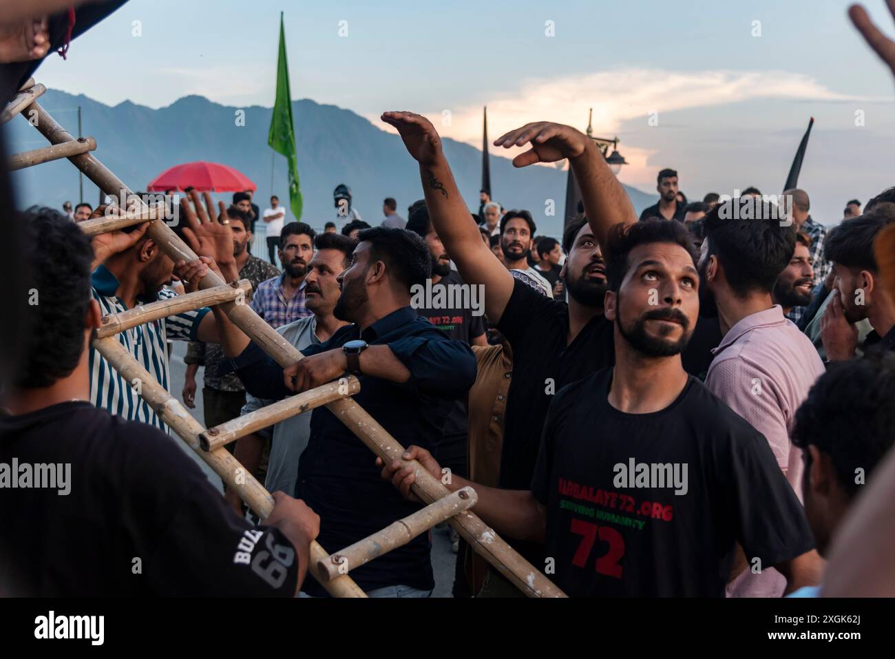 Kashmiri Shia Muslims erect a tall religious flag on a road during ...
