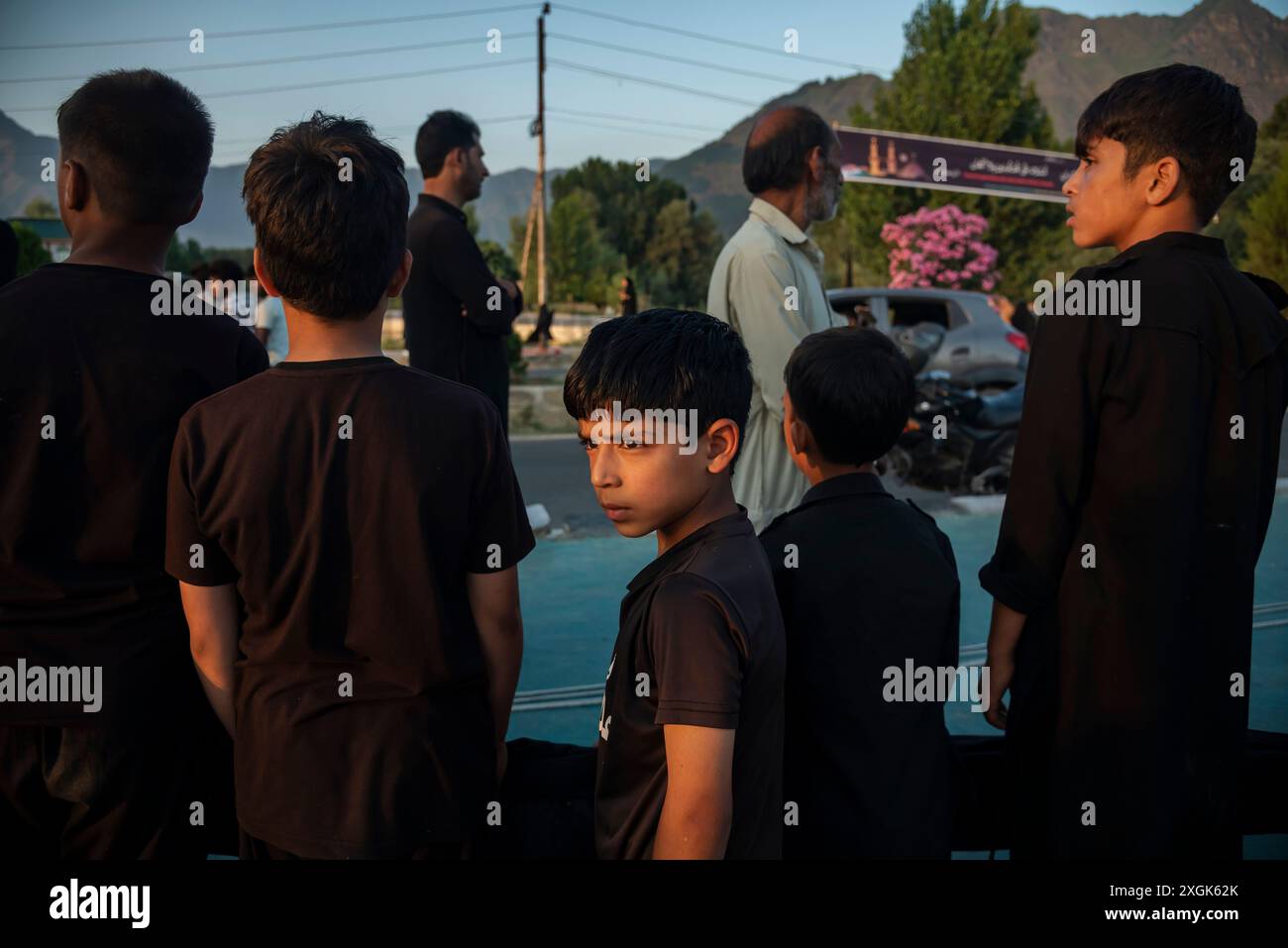 A Kashmiri Shia Muslim boy looks on as he helps to install a tall ...