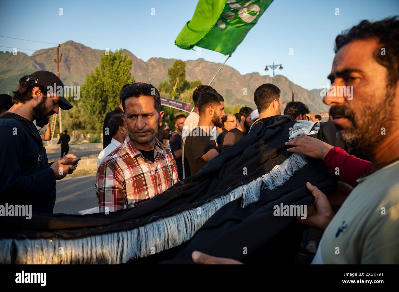 Kashmiri Shia Muslims prepare a religious flag to install on a road ...