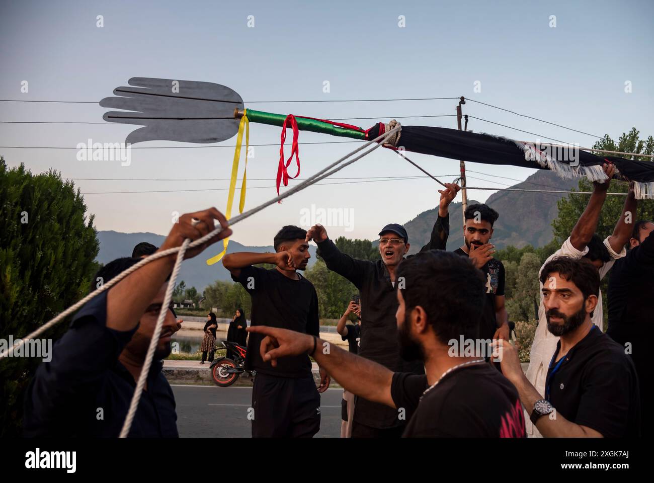 Kashmiri Shia Muslims install a tall religious flag on a road during ...
