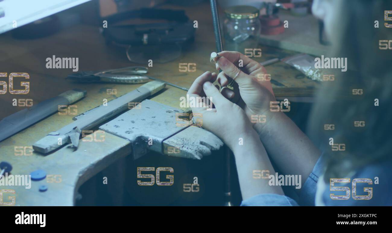 Image of multiple 5g texts over caucasian woman looking at ring in workshop Stock Photo