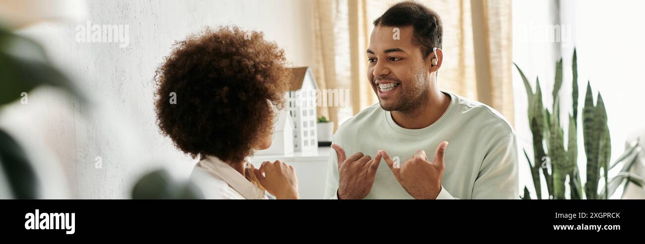 A couple communicates using sign language in their home. Stock Photo