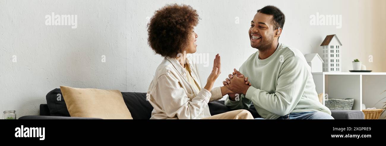 A loving couple using sign language to communicate at home. Stock Photo
