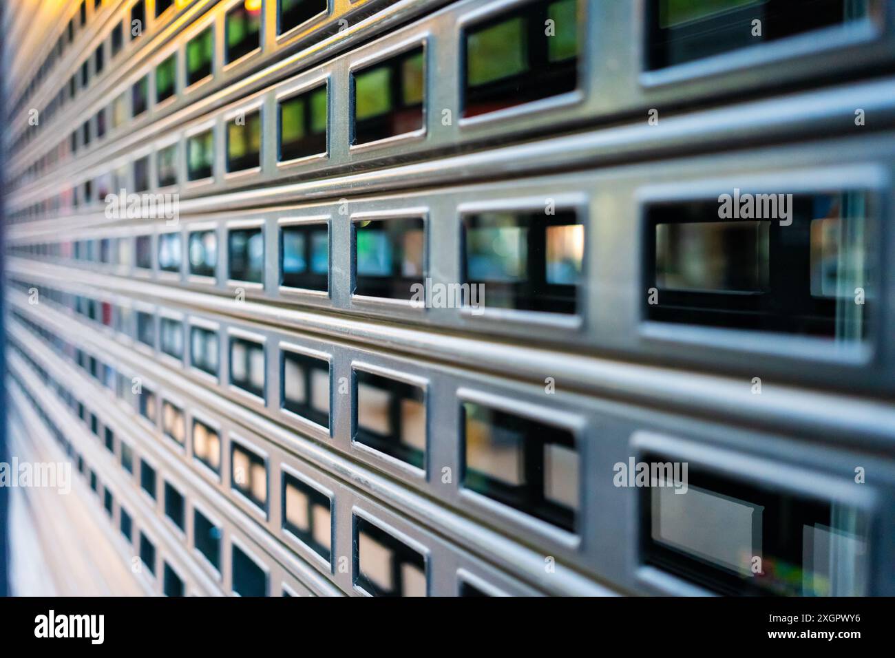 Detailed close-up of a metal grid fence with a blurred background. The ...
