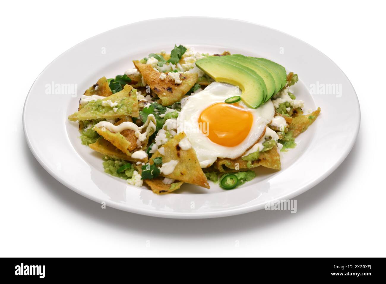 chilaquiles, Mexican breakfast. Totopos topped with salsa verde, fried egg, and avocado. Stock Photo