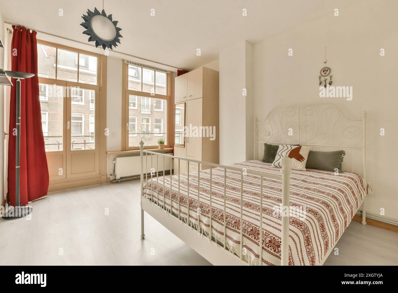 A modern and airy bedroom featuring large windows, minimalistic design