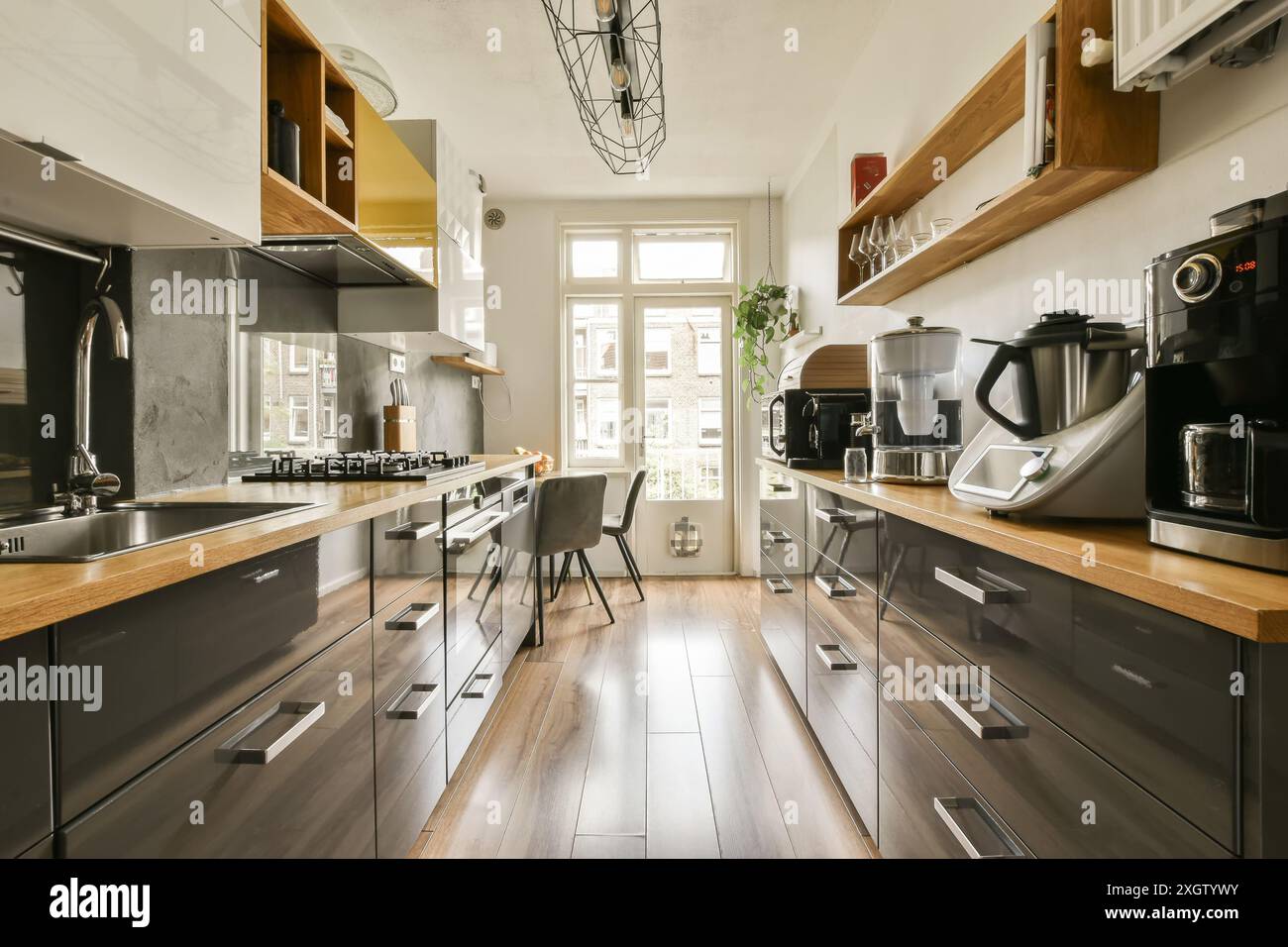 Elegant modern kitchen featuring dark cabinetry, high-end appliances ...