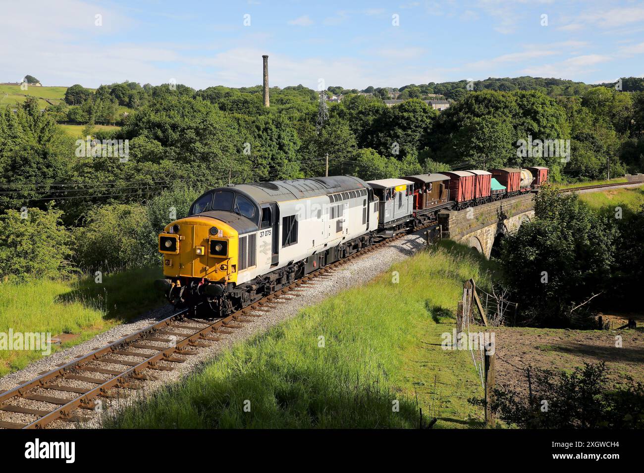 37075 heads the early morning goods past Mytholmes on 21.6.24. Stock Photo