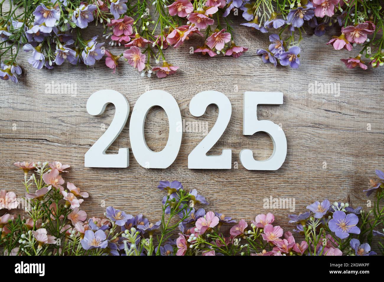2025 years number with flowers frame top view on wooden background. Hello, Welcome and Goodbye new year concept Stock Photo
