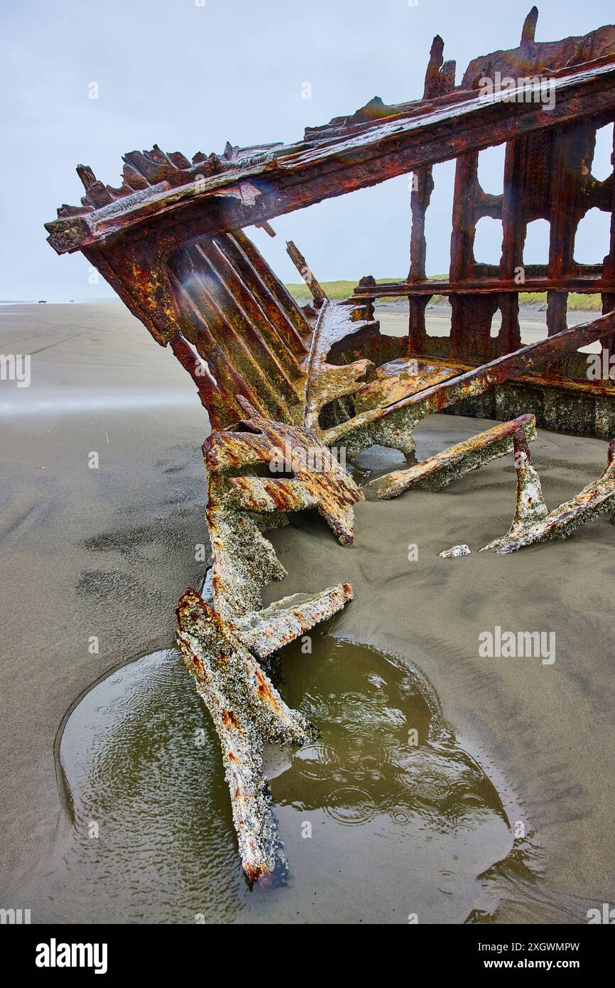 Rusty Shipwreck Remains on Sandy Beach Diagonal View Stock Photo