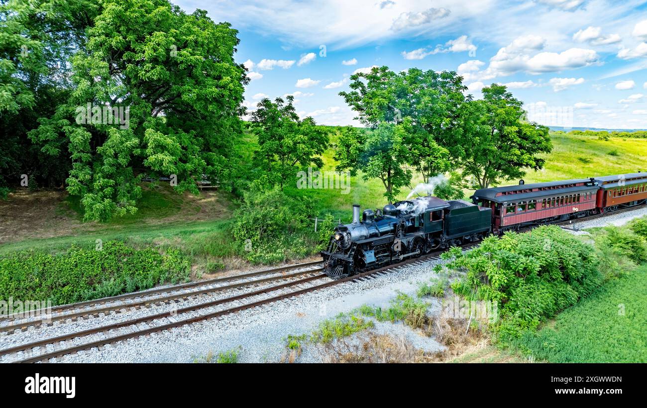 Steam Engine Rolling A Black Steam Locomotive Pulling Red Passenger Cars Travels Through A ...