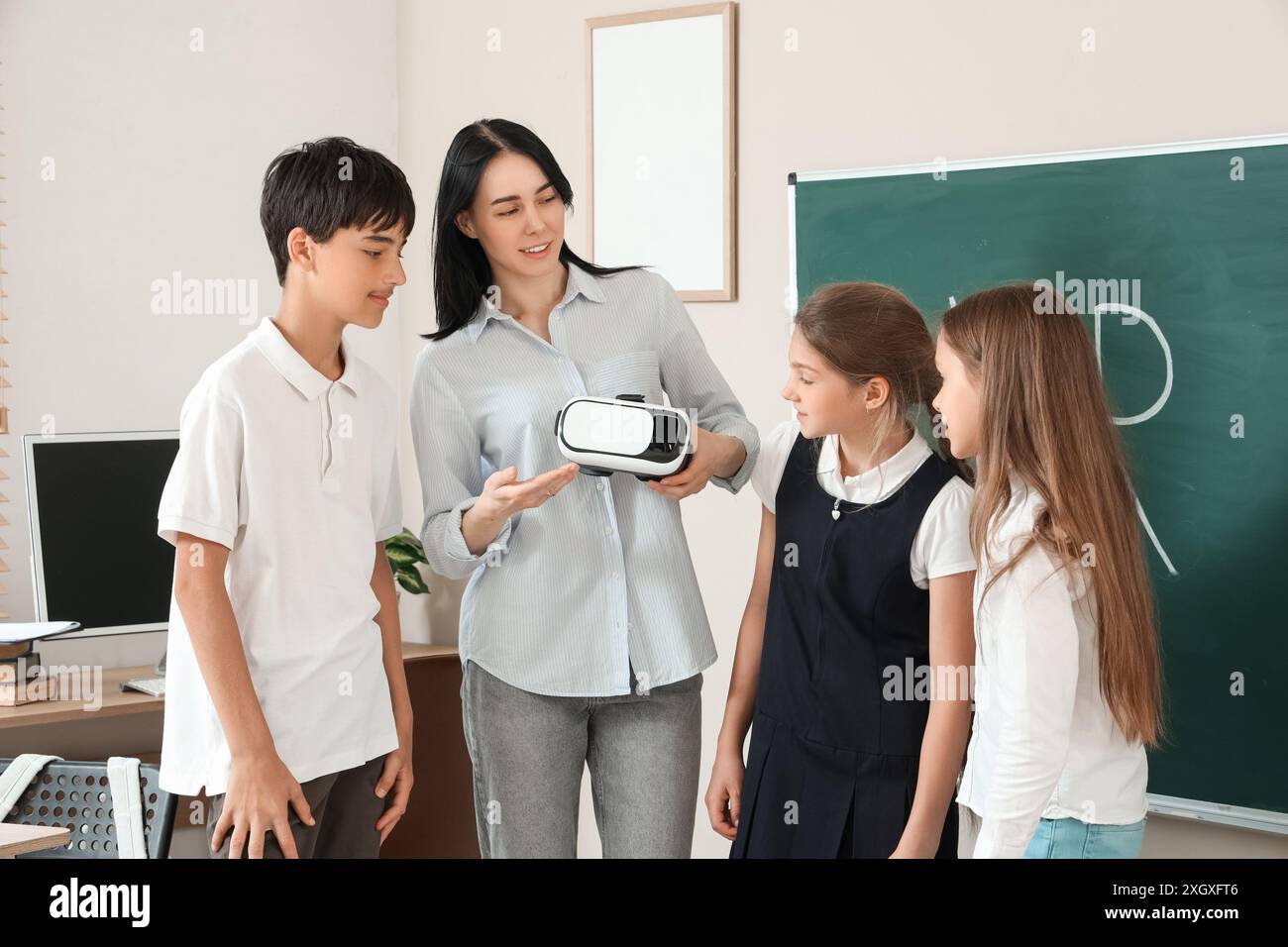 Female teacher showing VR glasses to pupils in classroom Stock Photo ...
