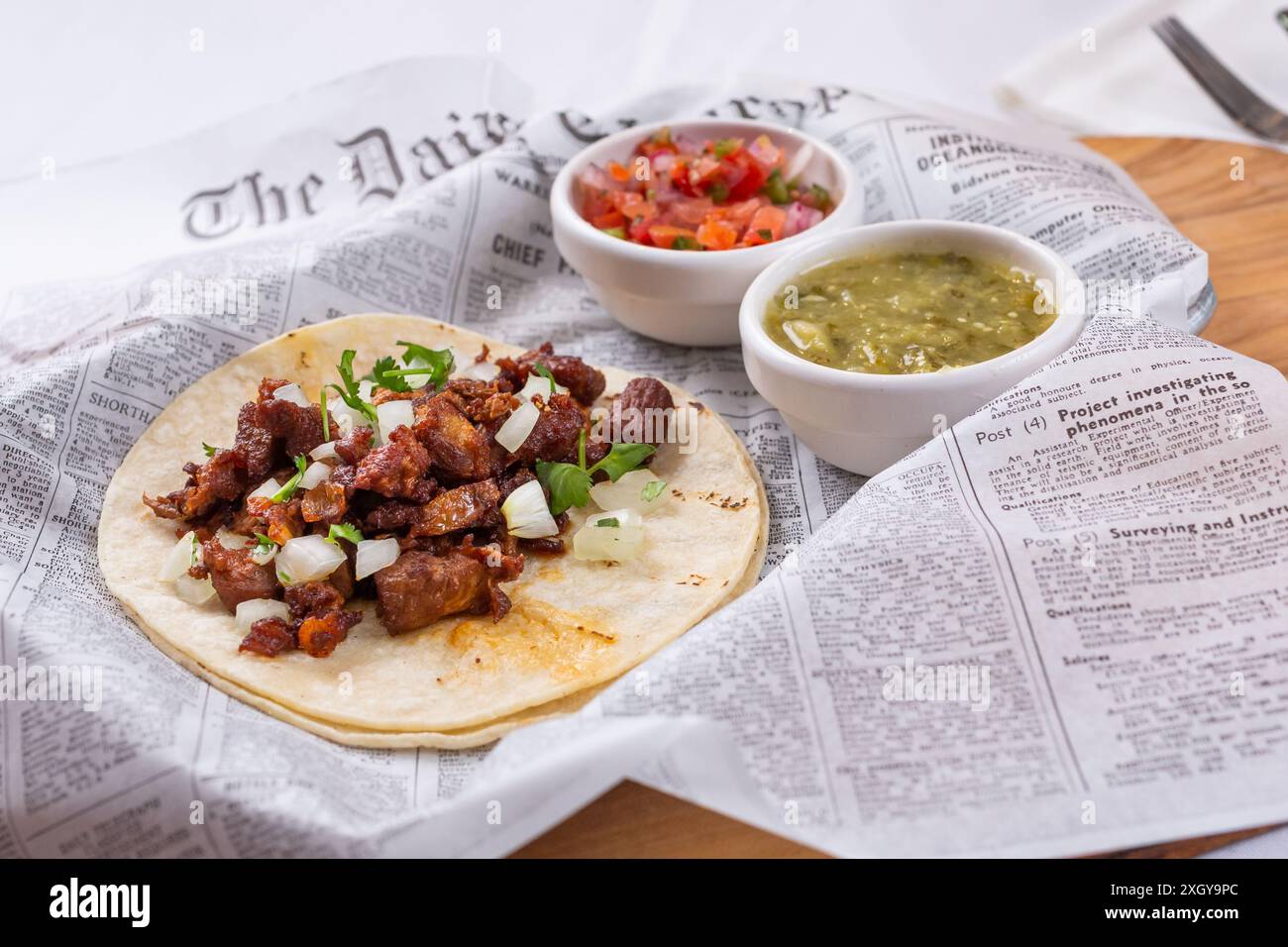 A view of an al pastor taco with condiments. Stock Photo