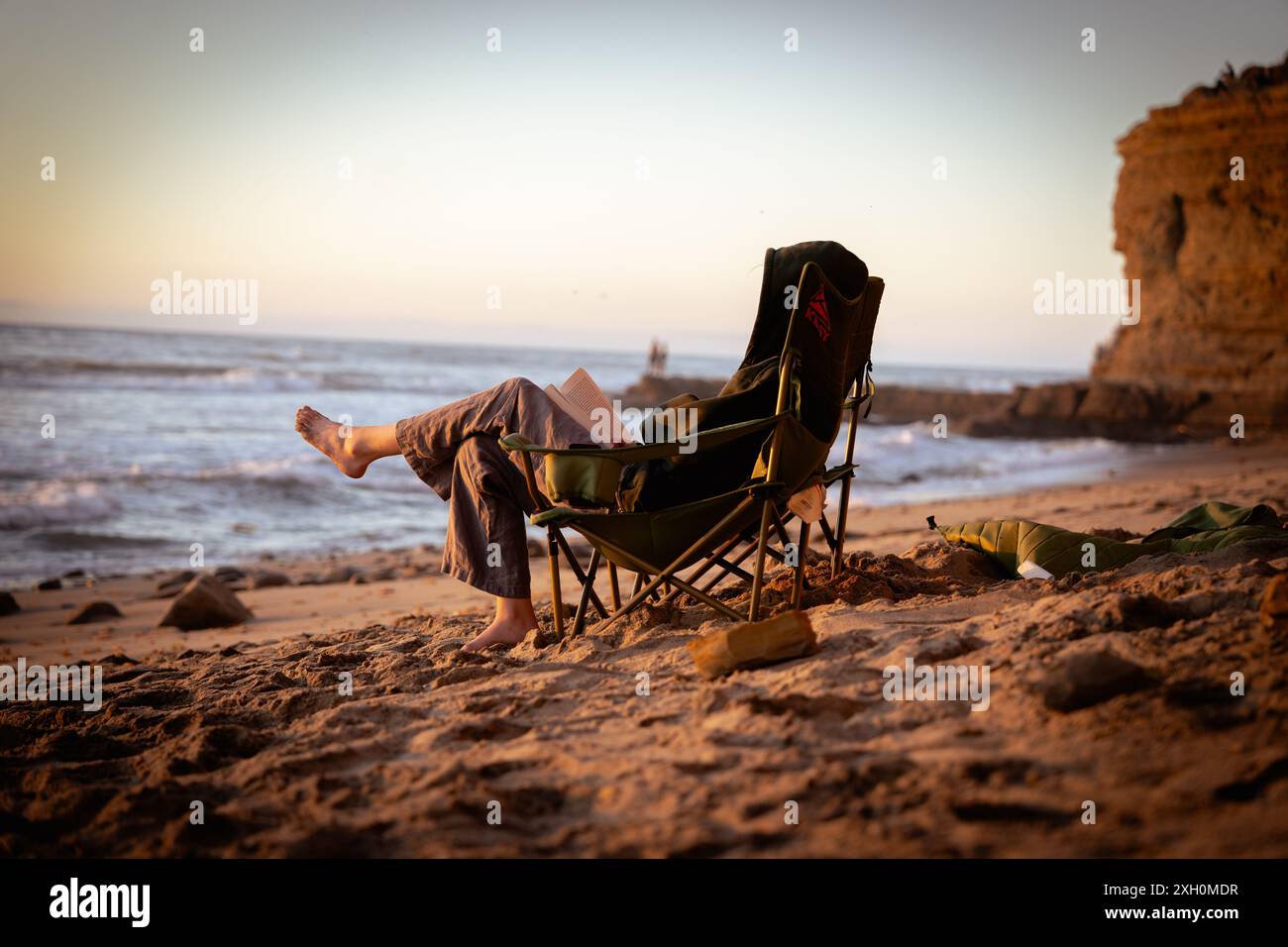 Person reading book on the beach at sunset hi-res stock photography and ...