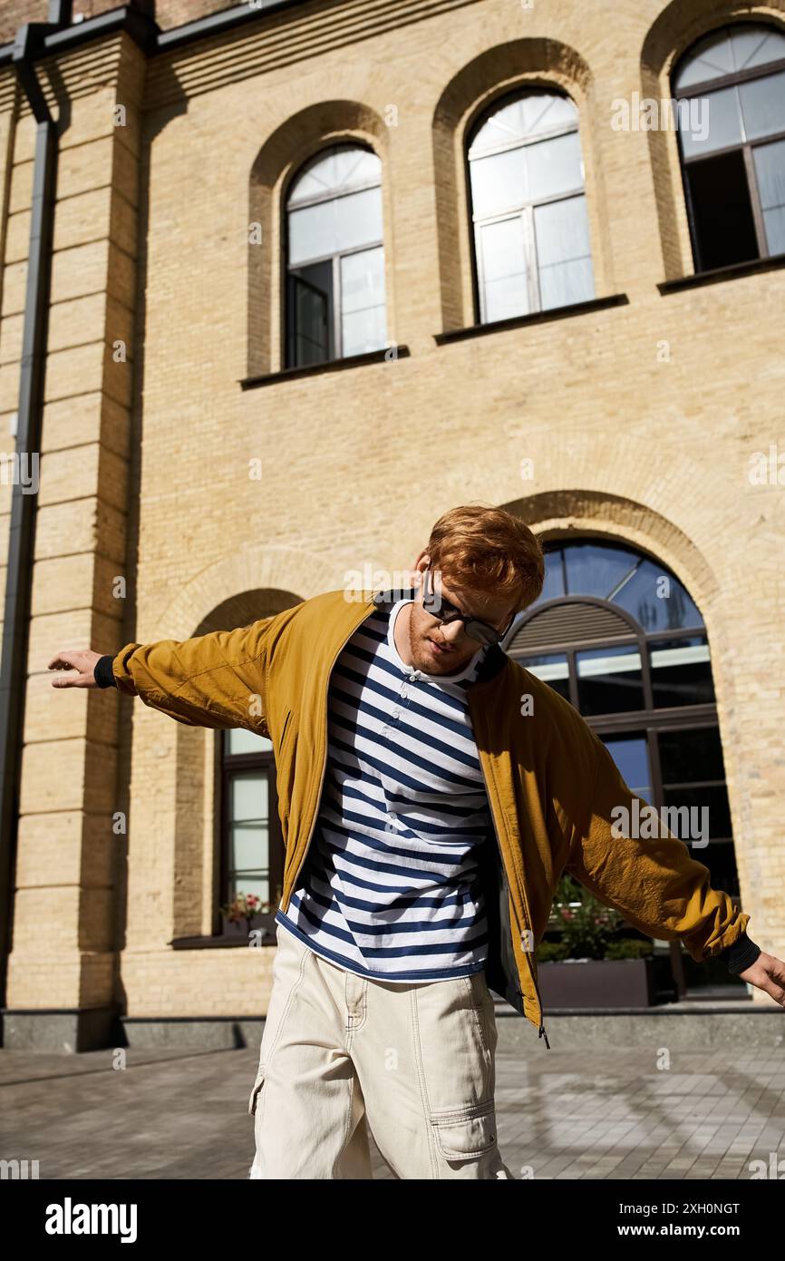 Stylish man with red hair taking walking in city sidewalk. Stock Photo