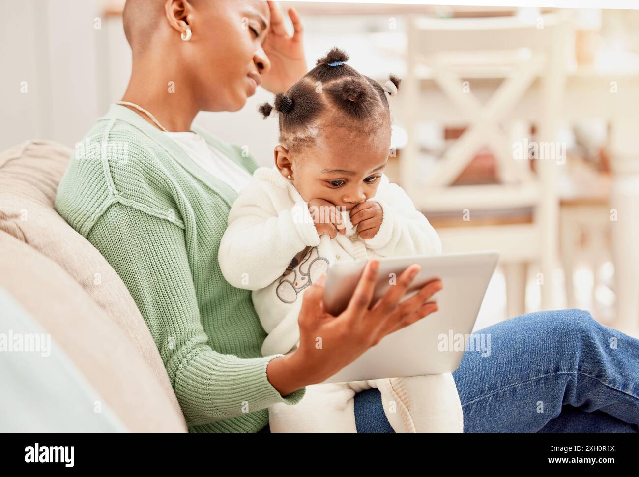 Headache, technology and mother with baby in home watching education video for child development. Postpartum depression, migraine and African mom with Stock Photo