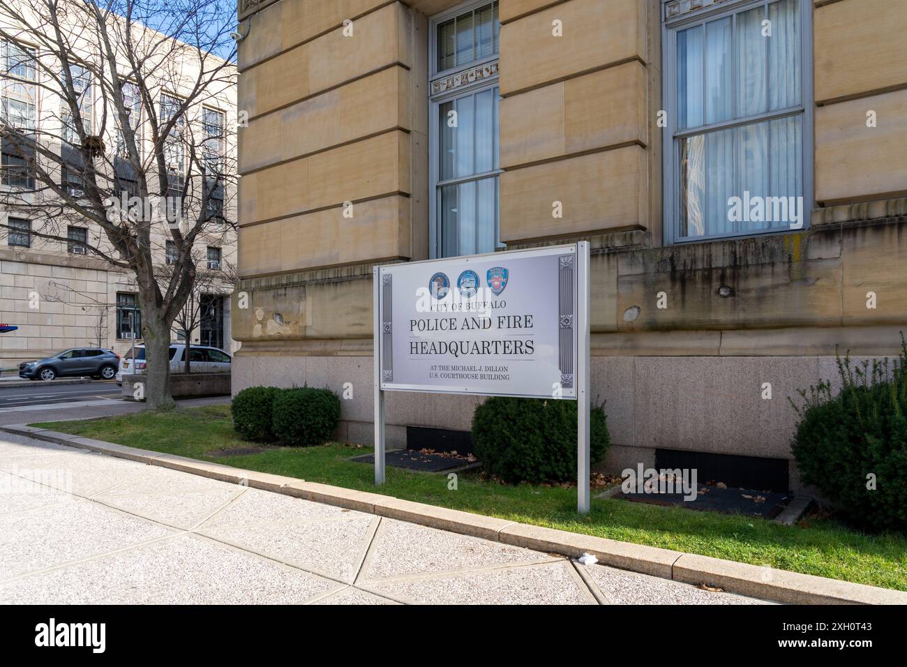 A yellow Pedestrian Crossing Sign with an office building background is shown. Buffalo, New York,  USA. Stock Photo