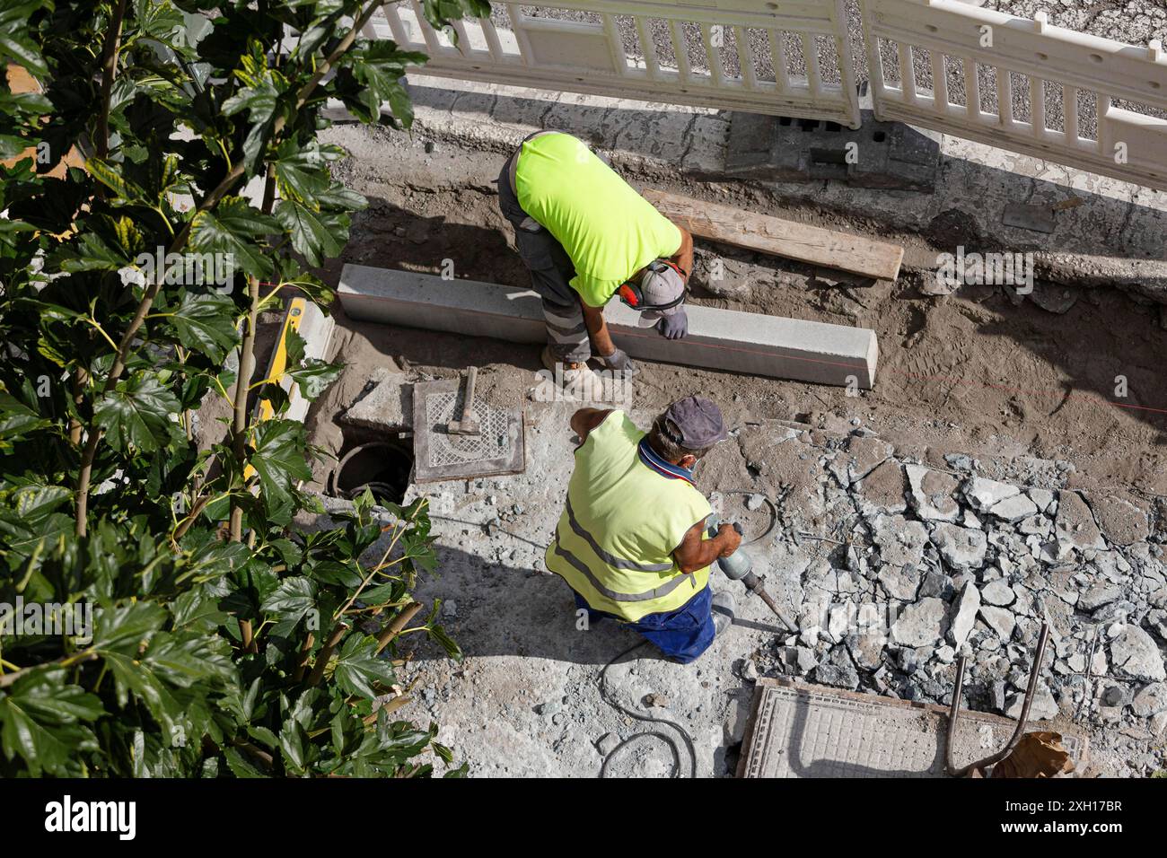 Construction workers working on sidewalk. City Maintenance concept Stock Photo