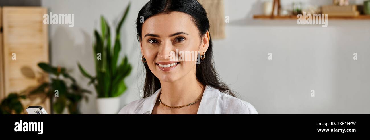 A stylish woman smiling at camera while working from home. Stock Photo