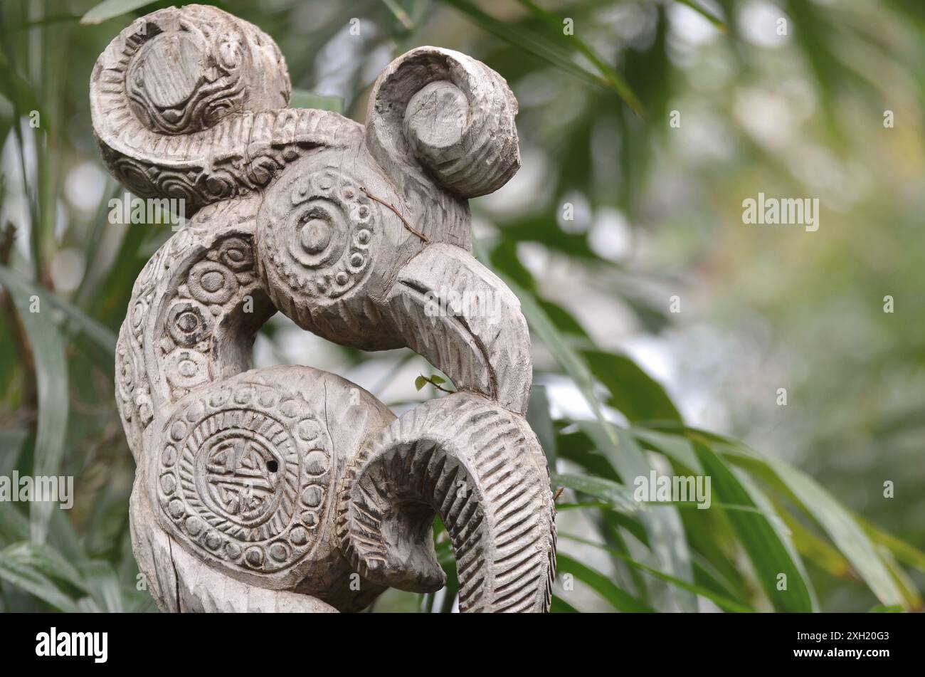 Southeast Asian overgrown tribal bird woodcarving in the jungle - Dayak Totem Stock Photo