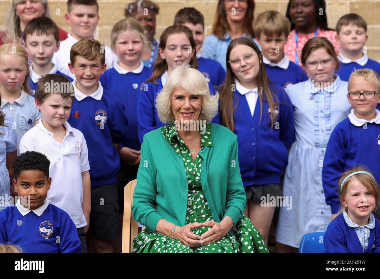 Queen Camilla poses for a photo with pupils during a visit to Lacock ...